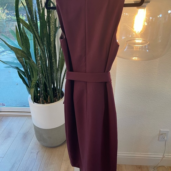 Sleeveless dress with belt and skirt has opening. - Picture 4 of 5